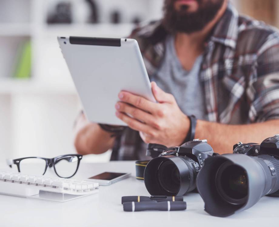 Young cheerful photographer with beard, while working in his office